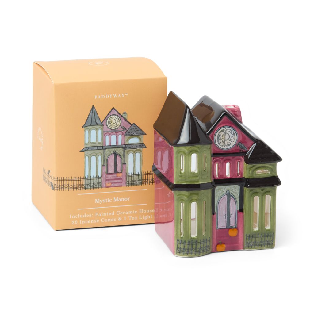 Ceramic house-shaped candle with decorative packaging on a white background