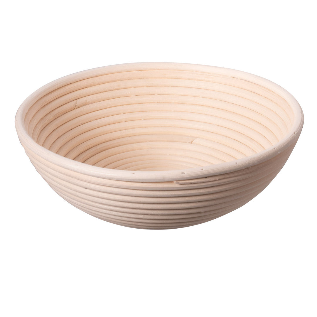 Round, woven bread proofing basket on a white background