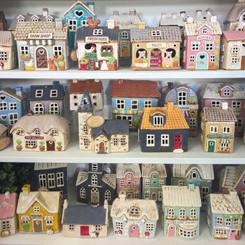 a shelfie of Village pottery tealight houses.