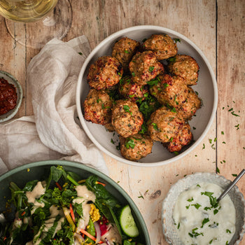 A plate of Shawarma meatballs on a table with sides.