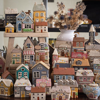 a shelfie of Village pottery tealight houses.