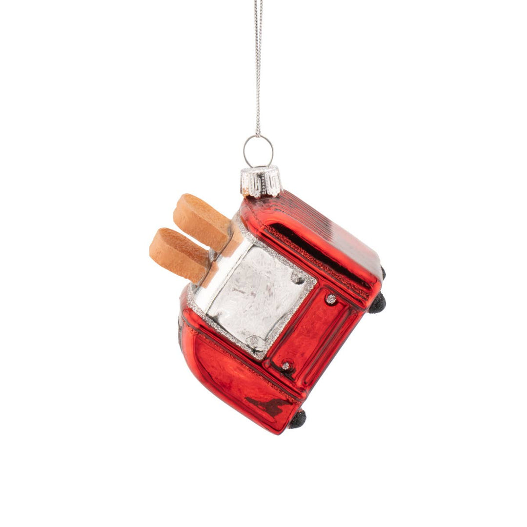 Red glass ornament shaped like a vintage toaster with a white background
