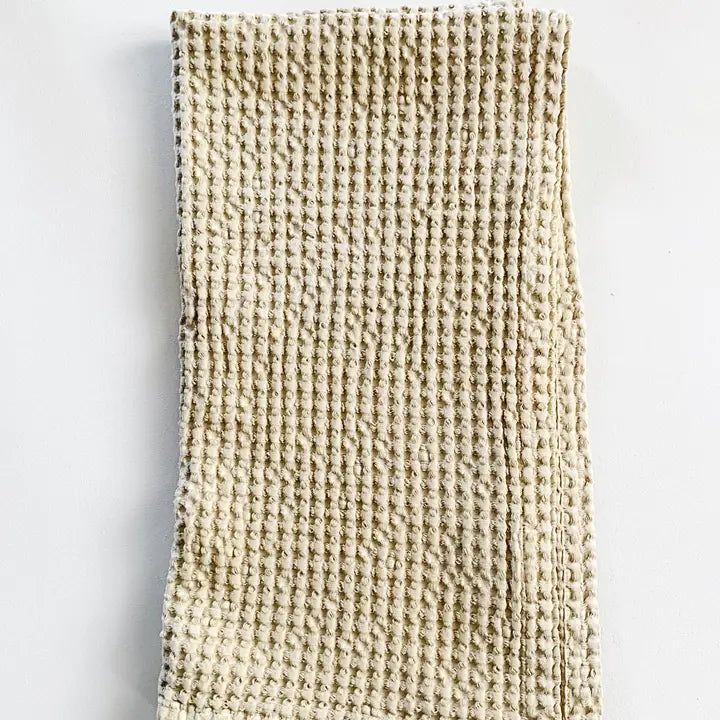 Textured beige tea towel on a light gray background
