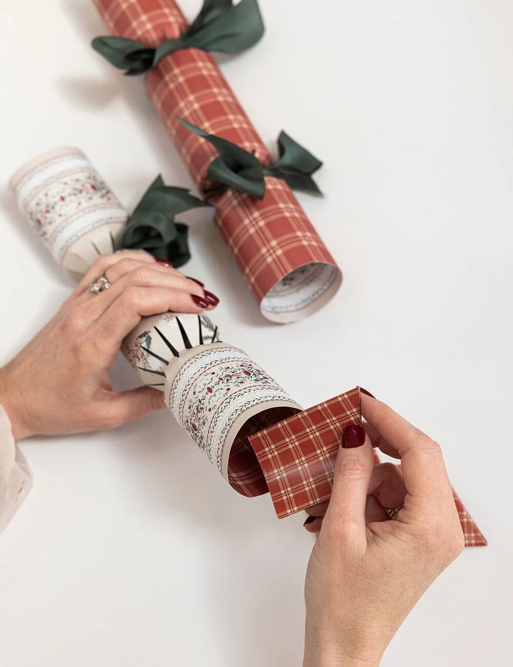Christmas cracker with plaid patterns and green ribbons on a white background.