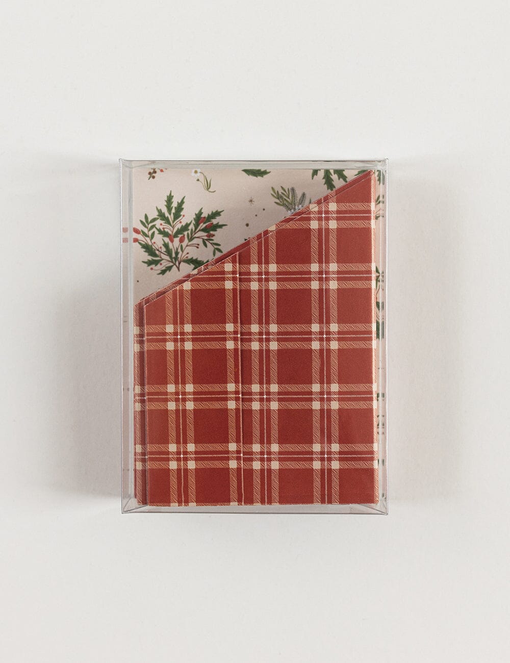 Packaged red plaid paper crowns on a white background