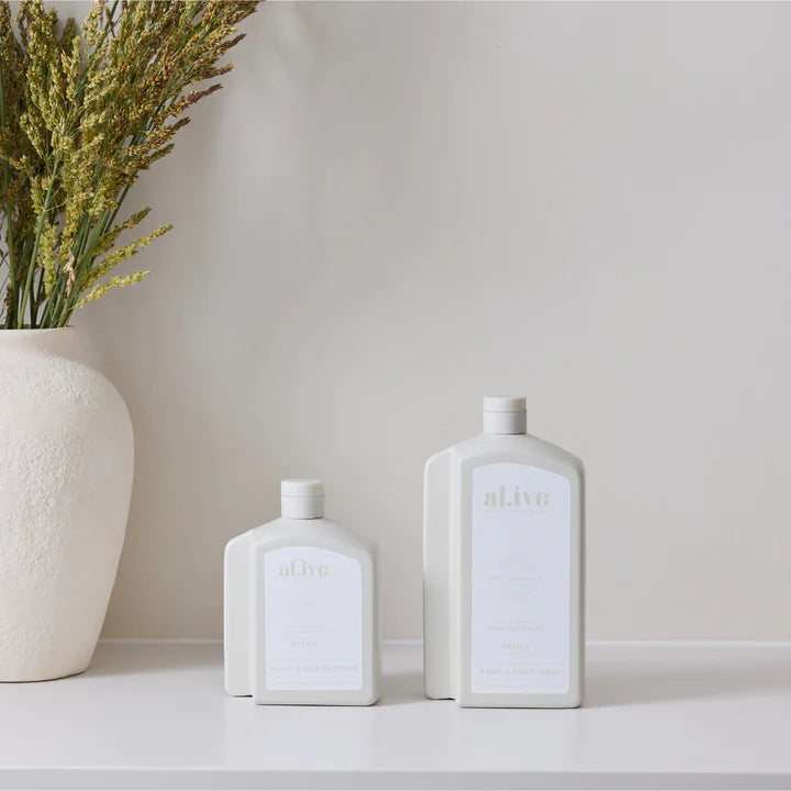 Three white ceramic bottles with 'alive' branding on a neutral background