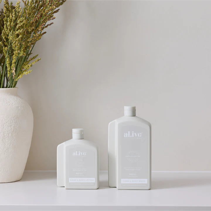 Two white bottles labeled 'alive' on a light surface with a neutral background
