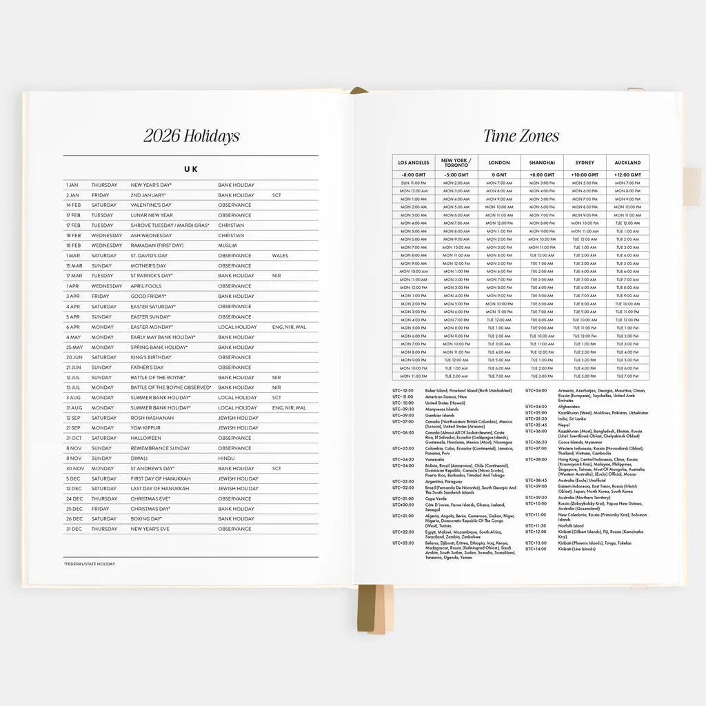 Open planner showing pages with 2026 holidays and time zones on a white background
