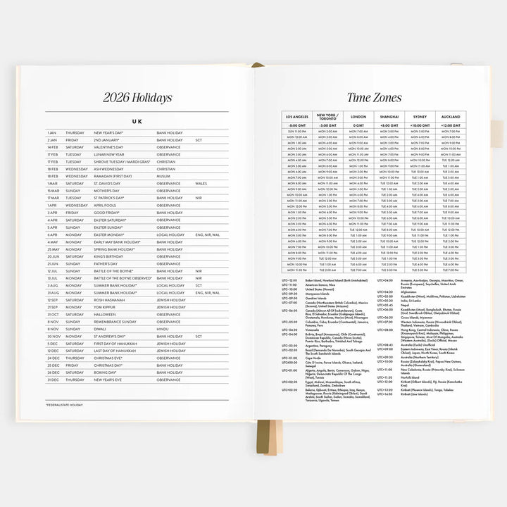Open planner showing pages with 2026 holidays and time zones on a white background