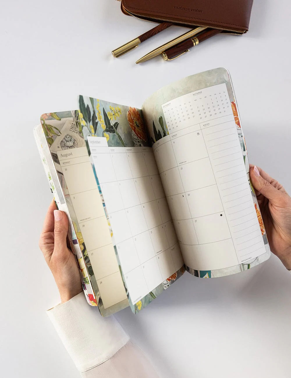Open planner with floral design on a white surface