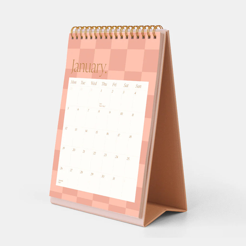 Desk calendar with a pink checkered design on a white background