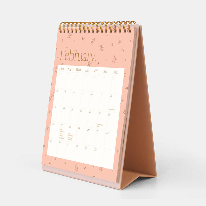 Desk calendar with a pink stand on a white background