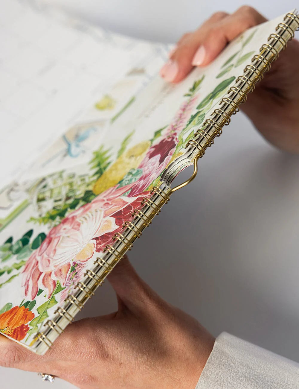 Floral notebook held by a person with a neutral background