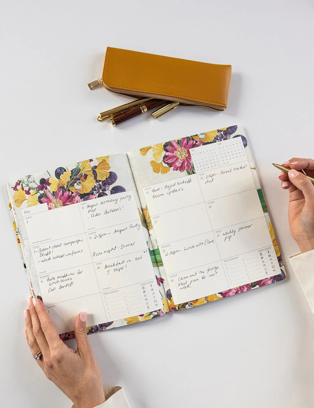 Floral planner with a pen holder on a white surface