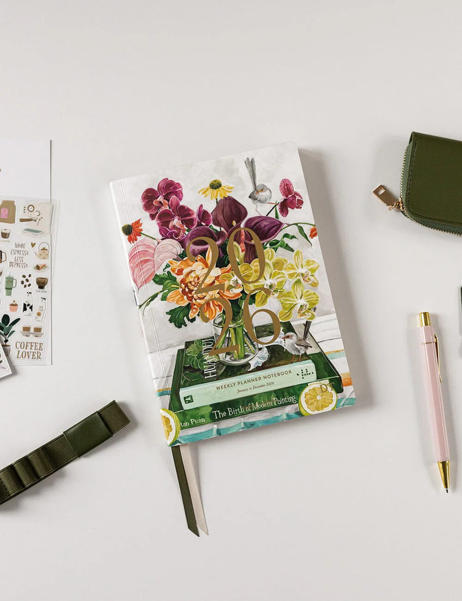 Floral 2026 planner with a pen and pouch on a white surface