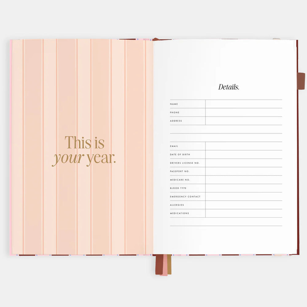 Open planner with motivational quote and contact details on a white background