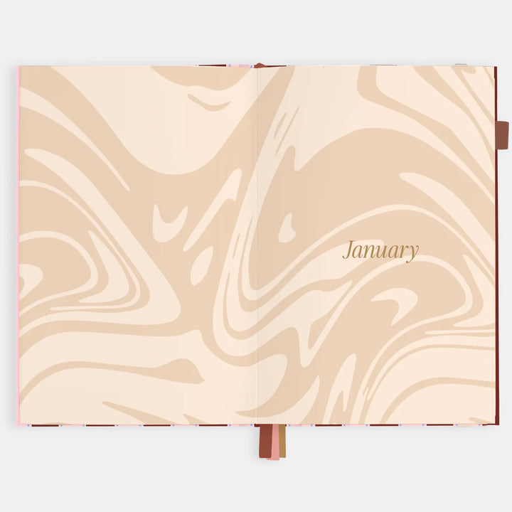 Marbled page in a beige planner with 'January' text on a white background