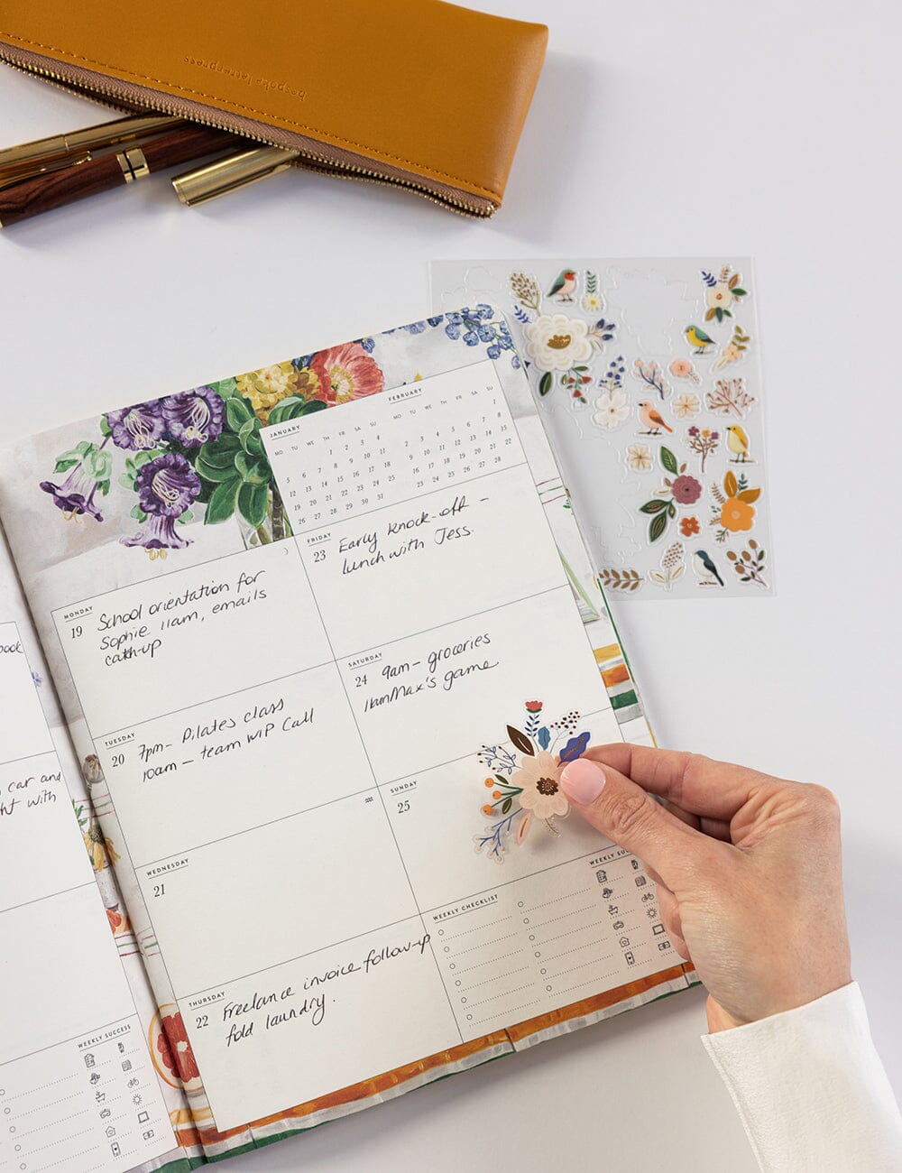 Planner with floral stickers on a white surface