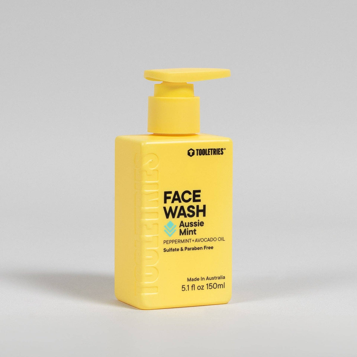 Yellow pump bottle of face wash with the words 'Aussie Mint' and peppermint + avocado oil, on a white background