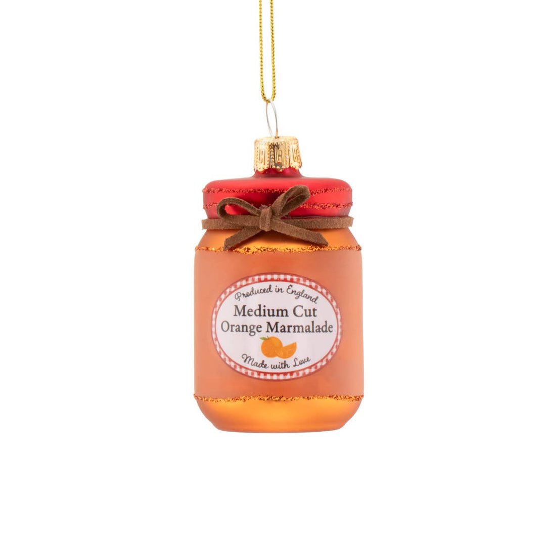 Decorative glass ornament shaped like a jar of medium cut orange marmalade with a red lid on a white background.