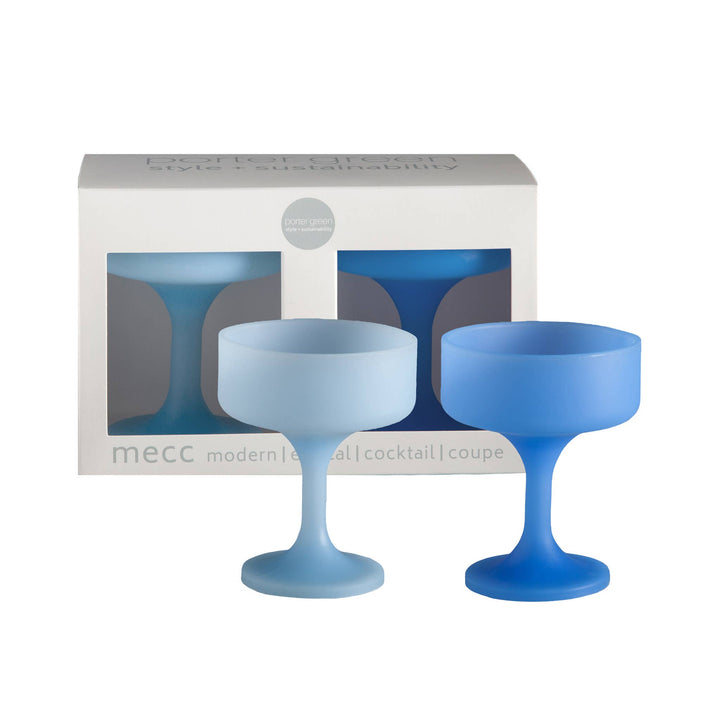 Two blue silicone cocktail coupes in front of their packaging box on a white background