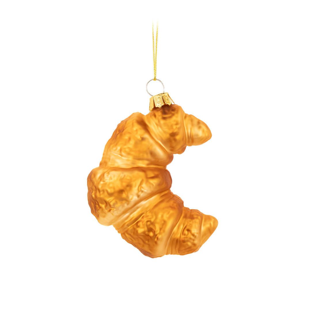 Glass ornament shaped like a croissant on a white background