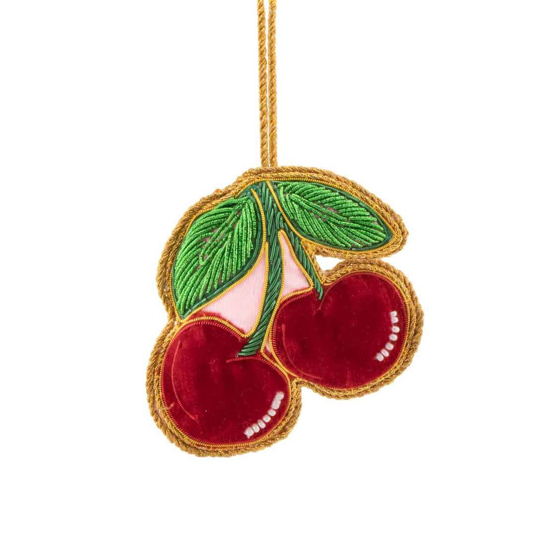 An embroidered cherry ornament featuring two red cherries with green leaves and a gold cord for hanging, shown on a plain white background.