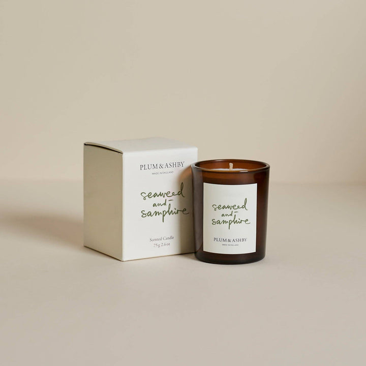 Plum &amp; Ashby candle and packaging on a beige background