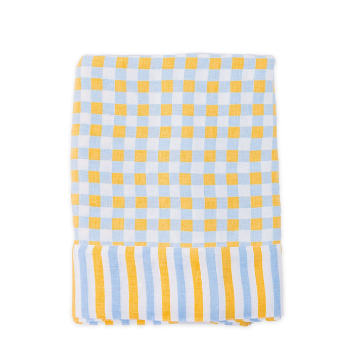 Yellow and chambray blue check patterned linen tablecloth laid flat on a white background