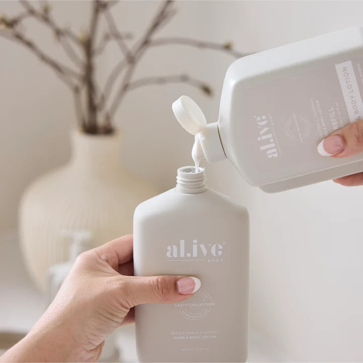 Person pouring a product from a white bottle labeled 'alive' into another similar bottle.