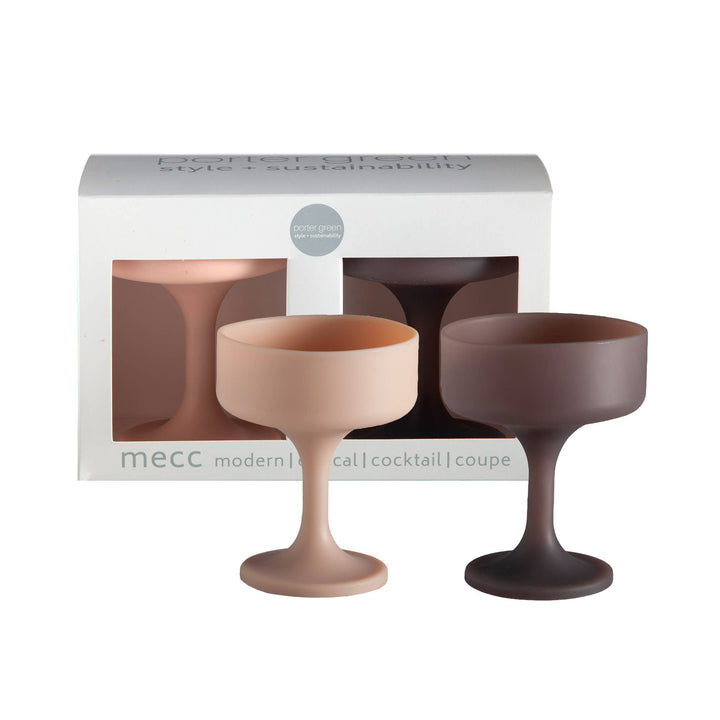 Two matte silicone cocktail coupe glasses in dusty pink and dark brown, displayed in front of their white Mecc packaging box on a white background.