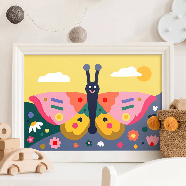 A framed colorful butterfly art print displayed on a white shelf in a styled nursery or children&