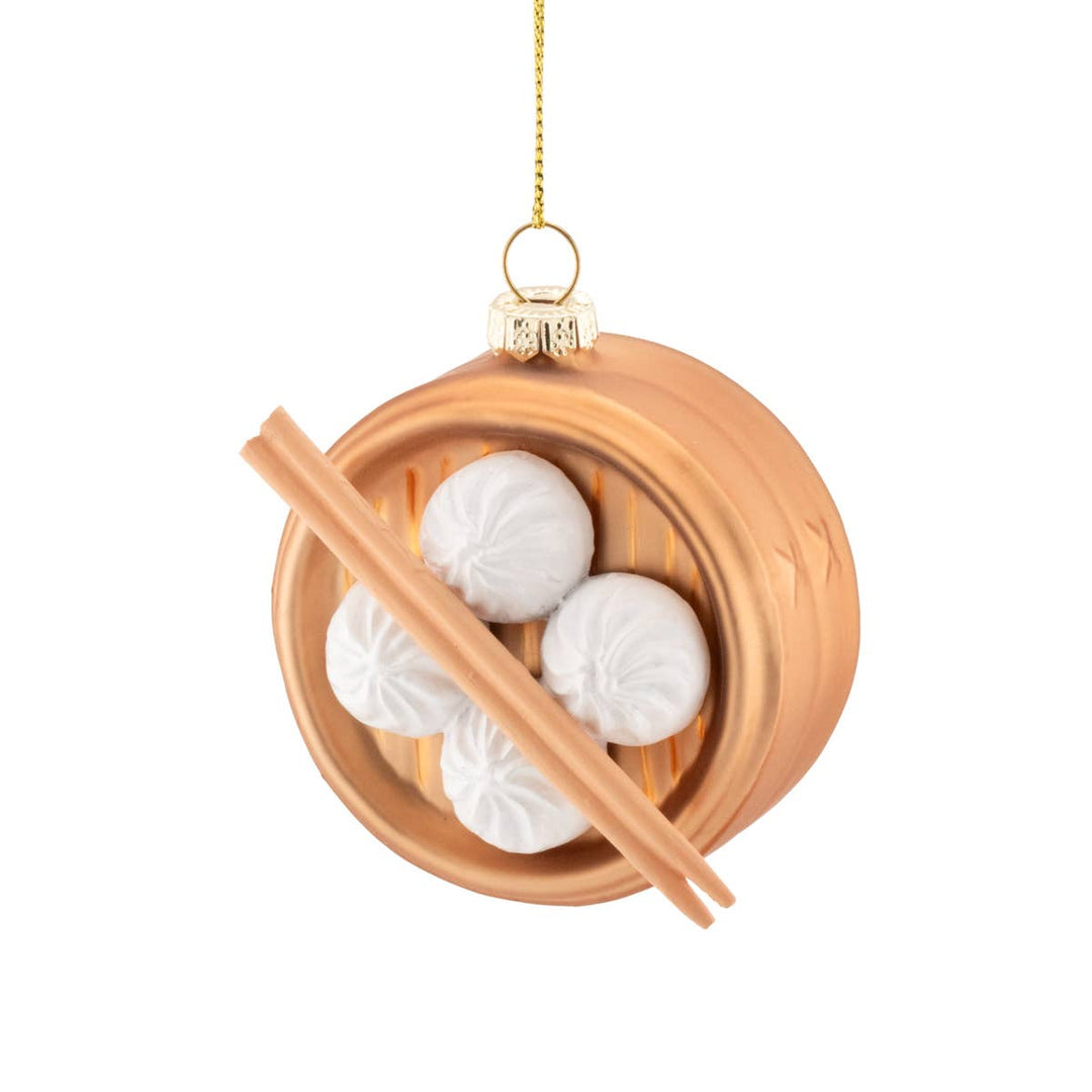 Decorative ornament of a bamboo steamer with white dumplings and chopsticks on a white background