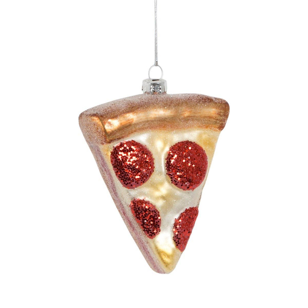 A glass Christmas ornament shaped like a slice of pepperoni pizza, featuring glittery red pepperoni circles on a white cheese face with a brown crust, hanging from a silver string against a white background.