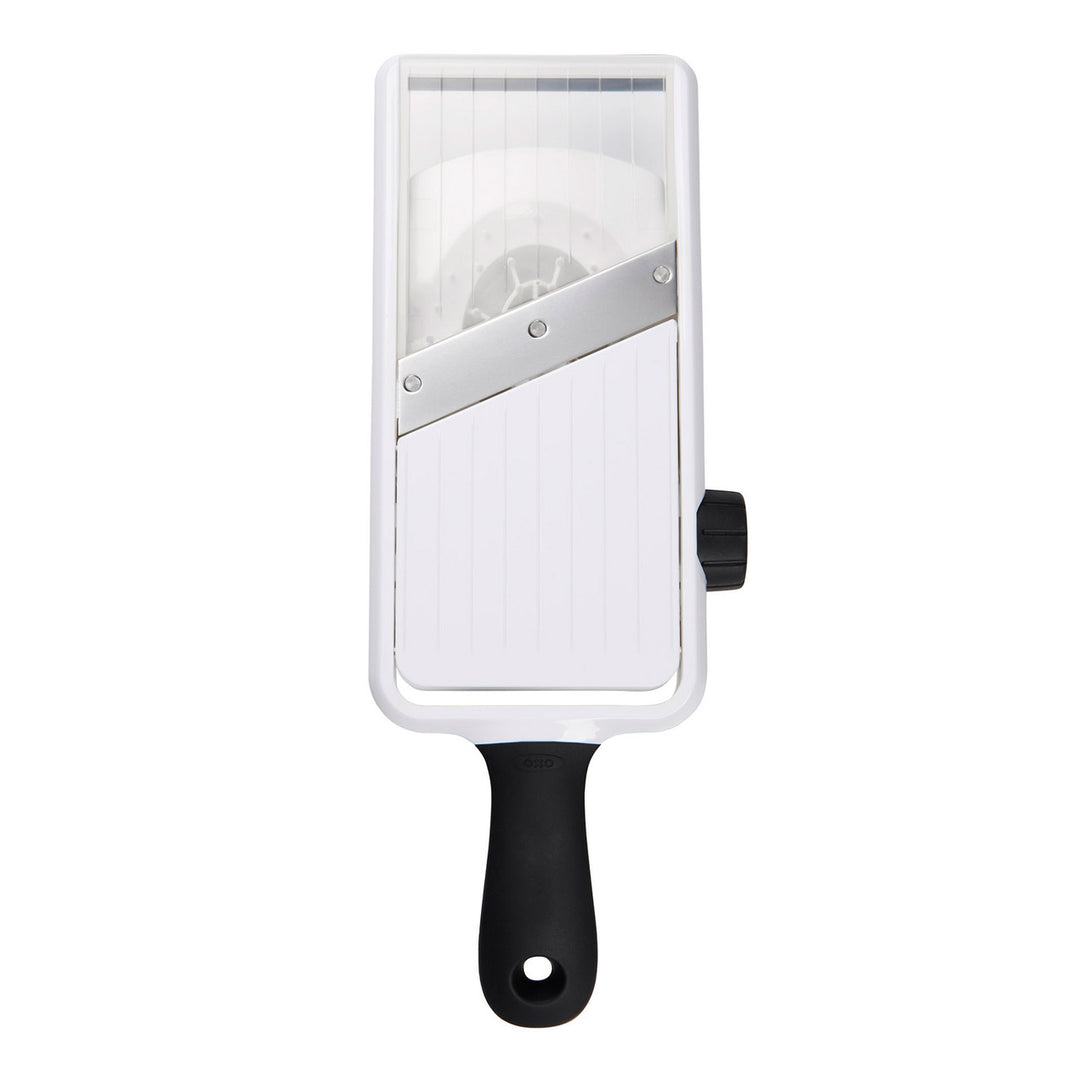 Handheld mandoline slicer with a white body and black handle on a white background