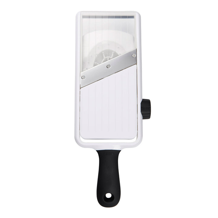Handheld mandoline slicer with a white body and black handle on a white background