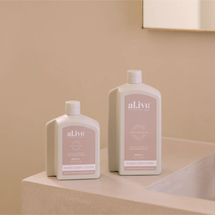 Two bottles of 'alive' lotion on a beige surface with a neutral background