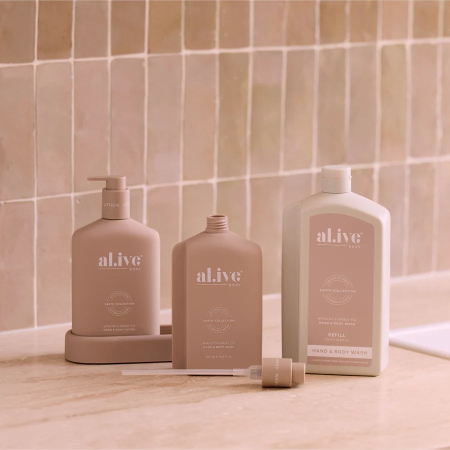 Three 'al.ive' skincare products on a bathroom counter with tiled wall background