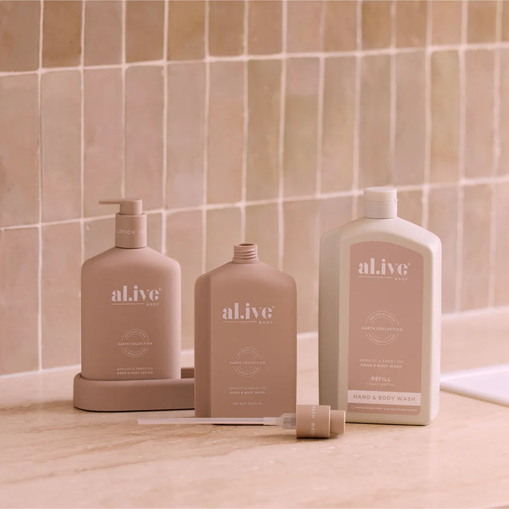 Three 'al.ive' skincare products on a bathroom counter with tiled wall background