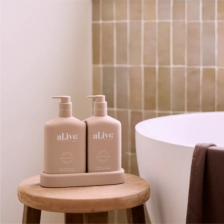 Two beige bottles labeled 'al.ive' on a wooden stool in a bathroom setting.