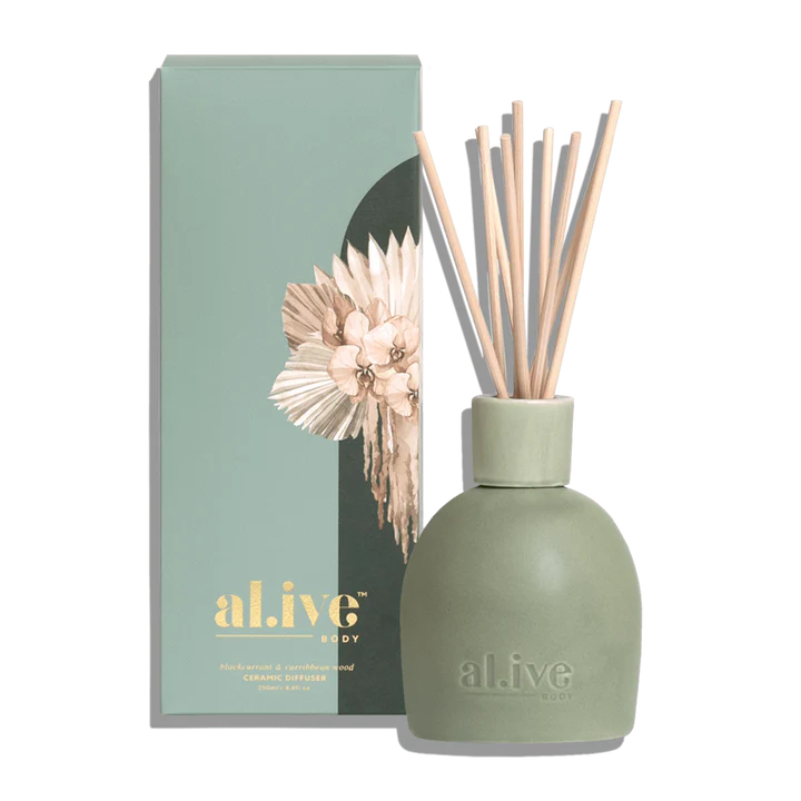 Green diffuser bottle with reeds and packaging displaying 'al ive' brand on a white background