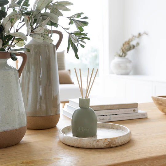 Decorative items including a diffuser, vases, and books on a wooden surface.