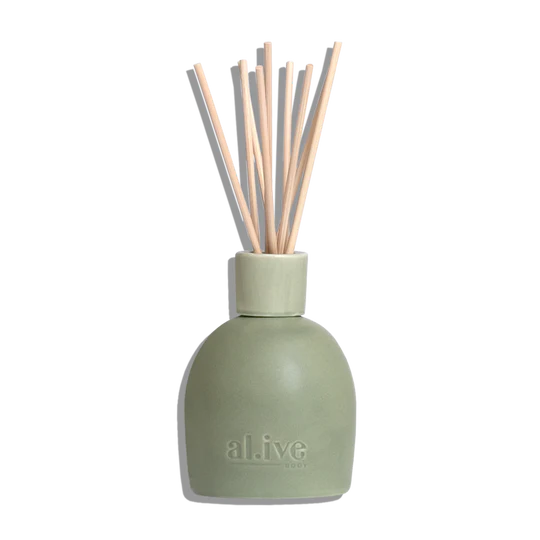 Green diffuser bottle with wooden sticks on a white background