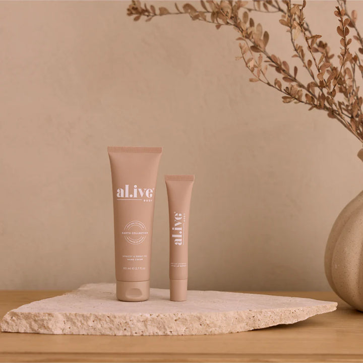 Two 'alive' skincare products on a stone surface with a beige background