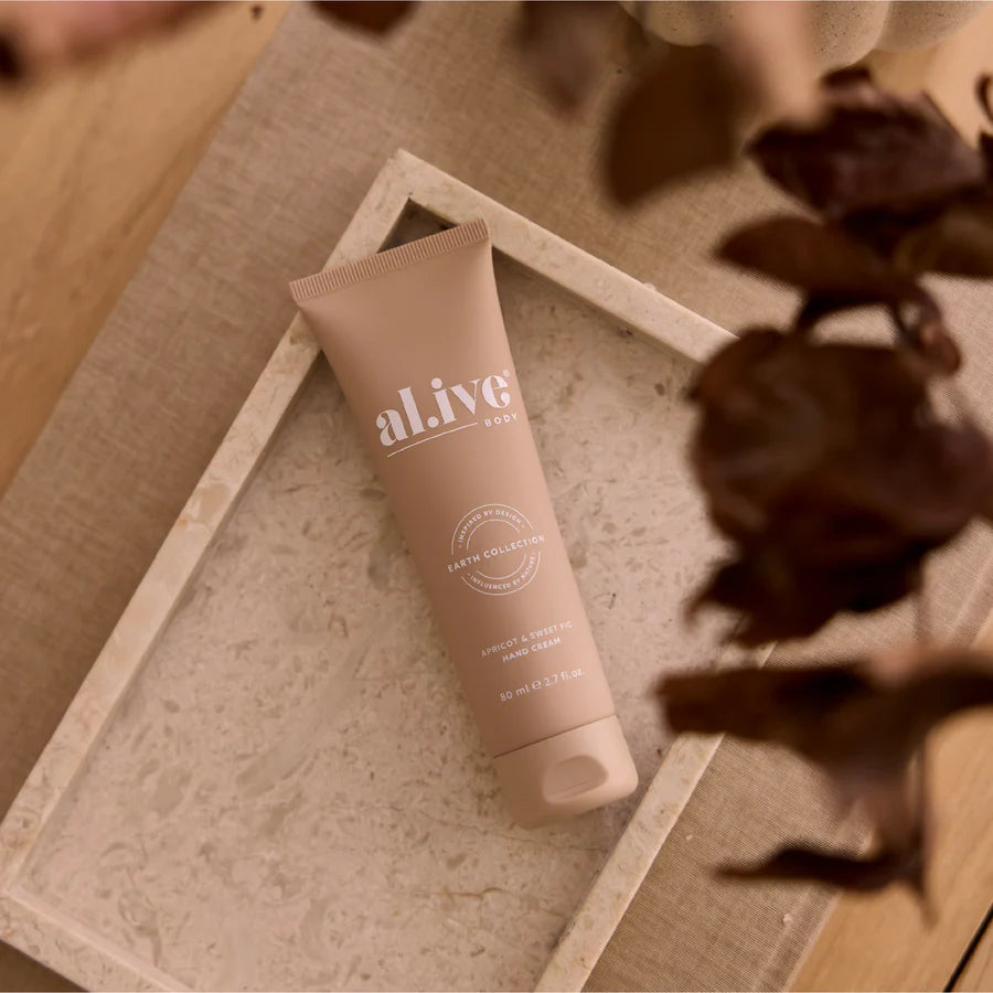 Tube of 'alive' cream on a textured surface with dried flowers