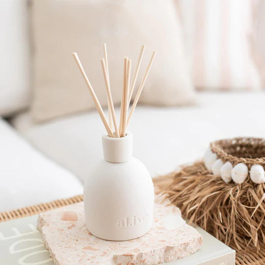 White diffuser with wooden sticks on a decorative surface