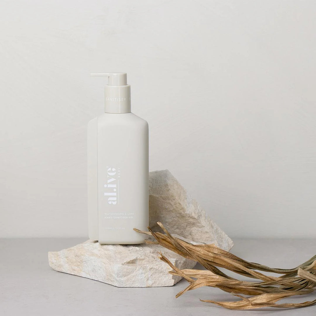 White bottle labeled 'alive' on a stone surface with a neutral background