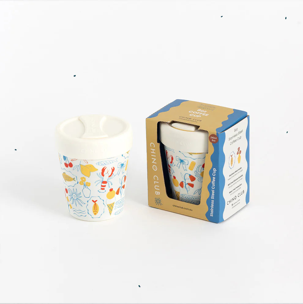 Colorful coffee cup with a pattern next to its packaging on a white background