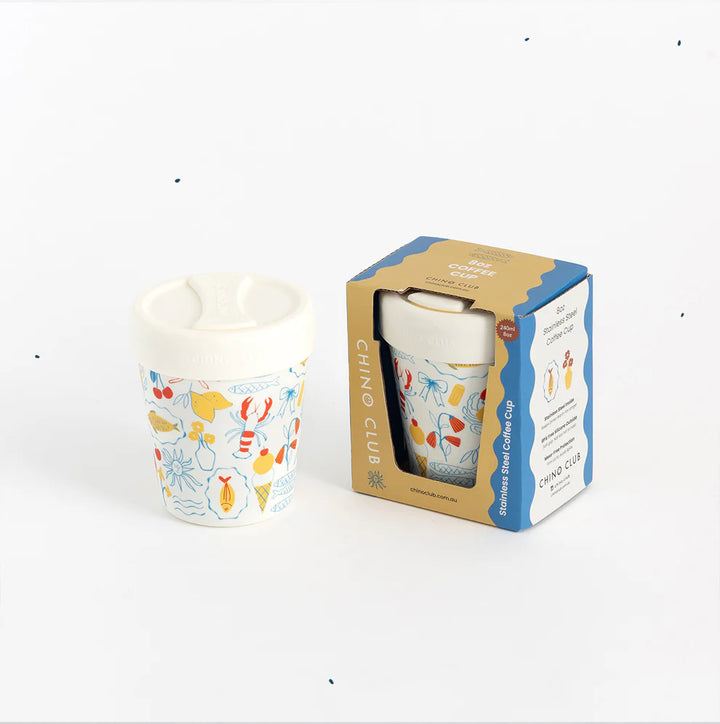 Colorful coffee cup with a pattern next to its packaging on a white background