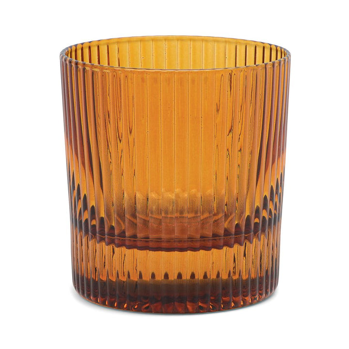 Amber glass tumbler with ribbed texture on a white background